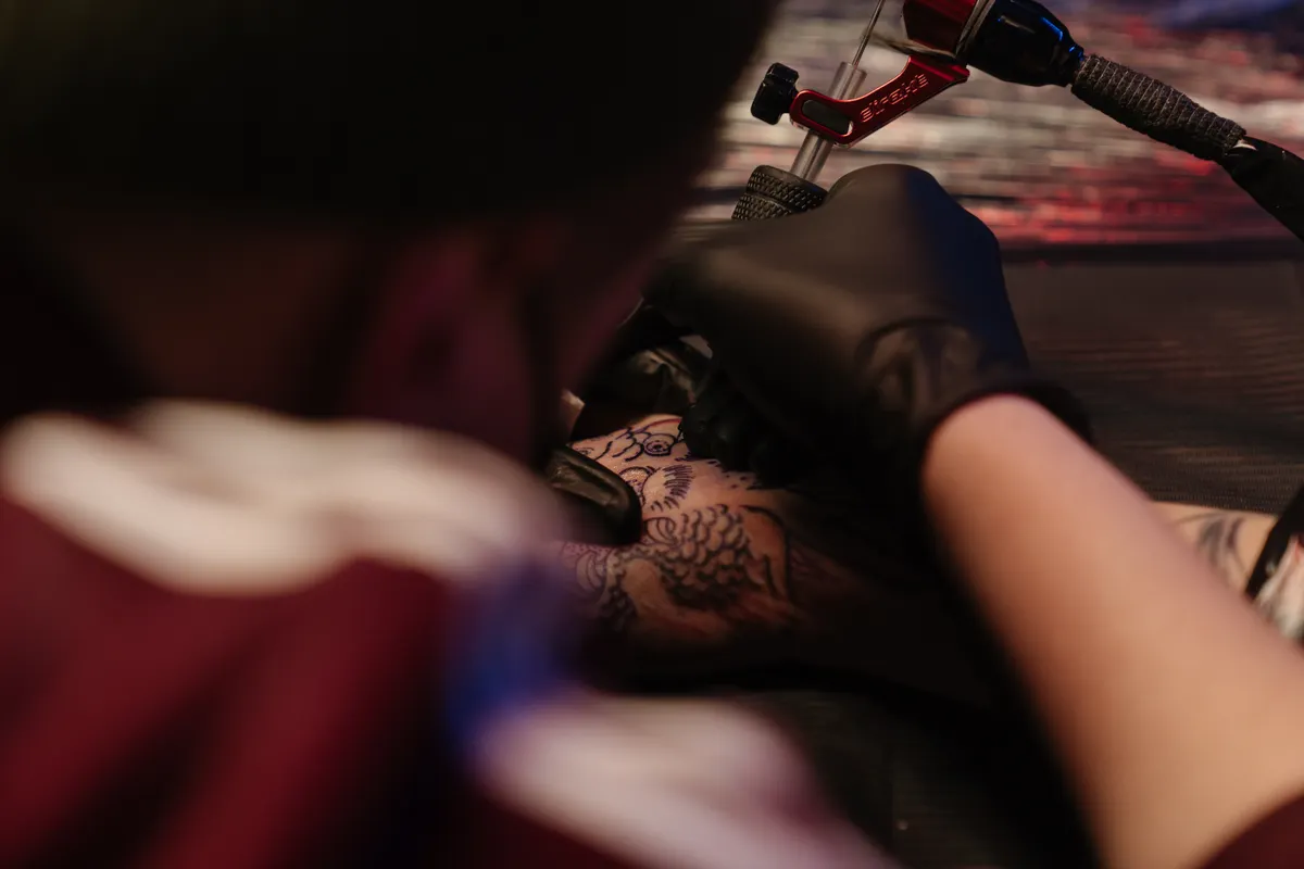 A colour tattoo being worked in on a client's arm at the studio